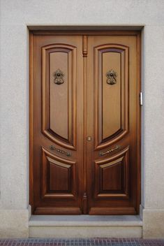 two wooden doors on the side of a building