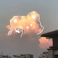 a cloud with some faces drawn on it and buildings in the backgrouds