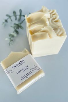 some kind of soap sitting on top of a white table next to a green plant