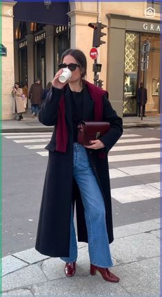 Step into fall with this effortlessly chic outfit that combines comfort and style. This look features a long black coat layered over a cozy sweater, paired with wide-leg jeans and bold burgundy ankle boots for a pop of color. The ensemble is completed with a sleek burgundy crossbody bag and classic sunglasses, perfect for an autumn stroll in the city. Elevate your fall wardrobe with this stylish and versatile outfit that’s perfect for everything from casual outings to city adventures. Burgundy Boots Ankle, Chique Outfit, Business Professional Outfits, Looks Jeans, Burgundy Outfit, Burgundy Boots, Elegante Y Chic, Skandinavian Fashion, Chique Outfits