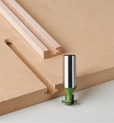 a piece of wood is being worked on with a green glue dispenser