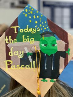 Painted graduation cap of Pascal and the words “today’s the big day Pascal!” Almost There Princess And The Frog Graduation Cap, Tangle Graduation Cap, Rapunzel Graduation Cap Ideas, Graduation Cap Designs Tiana, Tangled Themed Graduation Caps, Wall-e Graduation Cap, Grad Cap Ideas Tangled, Disney Inspired Graduation Caps, Tinkerbell Graduation Cap