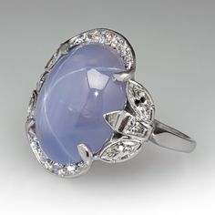 This stunning vintage ring is centered with an oval cabochon cut natural star sapphire set into a six-prong setting. The sapphire is bordered with ten (10), bead set, round brilliant cut diamonds, four (4), semi-bezel set, marquise brilliant cut diamonds and two (2), bezel set, tapered baguette cut diamonds. The ring measures 19.6mm at the top, rises 6.5mm above the finger, tapering to 1.4mm wide and 0.9mm thick at the base of the shank. It is currently a size 6. Luxury Domed Sapphire Ring Fine Jewelry, Luxury Cabochon Sapphire Wedding Ring, Luxury Heirloom Sapphire Open Ring, Vintage Oval Cabochon Gemstones, Fine Jewelry Silver Diamond Cabochons, Platinum Cabochon Jewelry For Anniversary, Oval Cabochons With Center Stone For Anniversary, Vintage Round Cabochon Gemstones, Vintage Round Cabochons For Anniversary