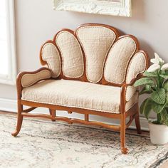 a small wooden chair next to a potted plant on a rug in front of a window