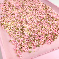 pink and gold sprinkles are scattered on top of each other in the shape of a rectangle