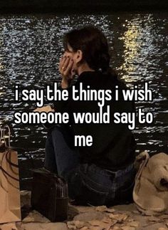 a woman sitting on the ground with her hand to her face next to some bags