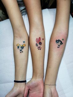 two girls with matching tattoos on their arms, both holding each other's hands