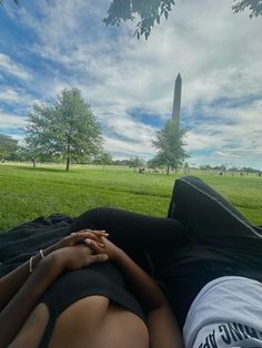 two people laying in the grass with their hands on each other's chests