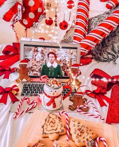 a laptop computer sitting on top of a table filled with cookies and candy canes