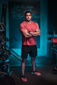 a man standing in front of a chalkboard with his arms crossed and looking at the camera