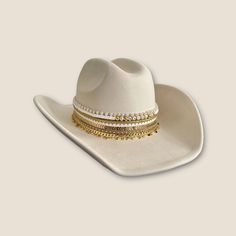 Channel your inner winter cowgirl with this stunning white fashion cowboy hat, embellished with sparkling beads and rows of dazzling jewelry. This show-stopping hat is the perfect way to add a touch of Western flair to any outfit, whether you're hitting the rodeo, dancing the night away at a country concert, or simply making a statement at your next brunch.       This hat features a classic cowboy silhouette with a wide brim and pinched crown. The star of the show, however, is the incredible embellishment: eight rows of sparkling beads and jewelry that cascade down the crown, catching the light with every move. You can customize the beadwork to spell out your name, your favorite saying, or even a special message for someone you love.       This hat is truly one-of-a-kind, and it's sure to White Cowboy Hat, Western Bachelorette, Custom Cowboy Hats, Country Bride, Bride Hat, Chapeau Cowboy, Country Concerts, Quality Hats, Cowgirl Hats