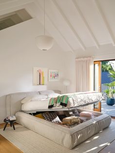 a bed sitting in the middle of a living room next to a sliding glass door