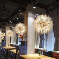 an empty restaurant with wooden tables and chairs, chandeliers hanging from the ceiling