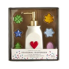 a soap dispenser in a gift box with cookies and leaves on it