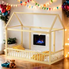 a child's bed with a lit fireplace in the middle and decorations around it