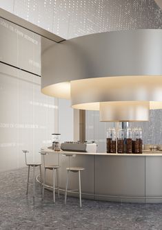 a large circular counter with stools in front of it and lights on the ceiling