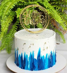 a white cake with blue and gold frosting