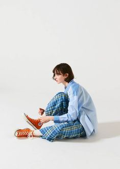 a woman sitting on the ground with an orange shoe