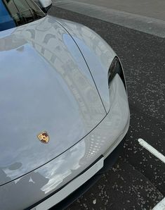 a silver sports car parked next to a parking meter