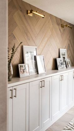 a room with white cabinets and pictures on the wall