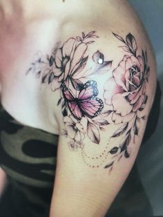 a woman's shoulder with flowers and butterflies on it, as well as a butterfly tattoo