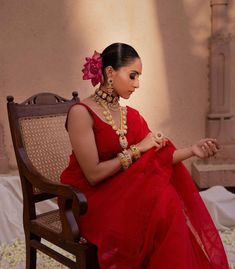 a woman in a red dress sitting on a chair