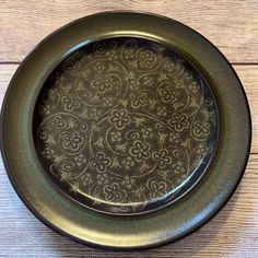 a brown and gold plate sitting on top of a wooden table