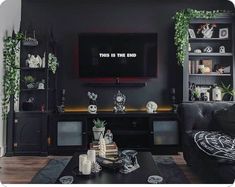 a living room with black furniture and a flat screen tv mounted on the wall above it