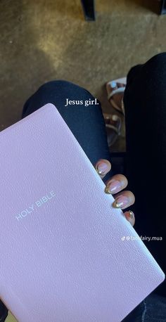 a woman's hand holding a pink laptop with the words jesus girl on it