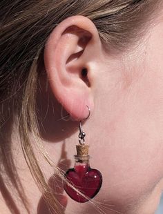 Red resin encased in resin heart shaped bottle earrings. These earrings are entirely made of resin and are shatter proof.  *Earring hooks are hypoallergenic stainless steel. *please see photo with US quarter for scale. If purchasing a set it will include one pair of earrings and one necklace. Heart Shaped Bottle, Health Potion, Unorganized Idea, Bottle Earrings, Earrings Heart, Potion Bottle, Earring Hooks, Heart Earrings, Jewelry Earrings Dangle