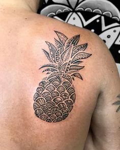 a man with a black pineapple tattoo on his back