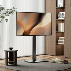 a flat screen tv sitting on top of a metal stand next to a book shelf