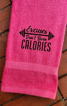 a pink towel with the words exercises don't burn calories on it sitting on a brick floor