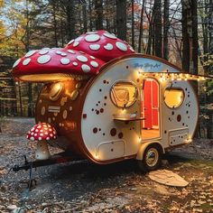 a mushroom shaped camper is lit up in the woods