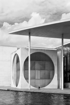 an architectural building with two circular windows on the front and sides, in black and white