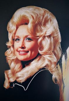 an old photo of a woman with blonde hair and blue eyes wearing a black dress