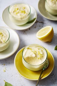 three plates with lemon custard desserts on them and one has a spoon in it