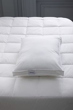 a white pillow sitting on top of a bed