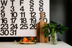 a cutting board sitting on top of a table next to a vase filled with oranges