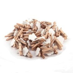 a pile of wooden clothes pegs with white and brown ones on them sitting on a white surface