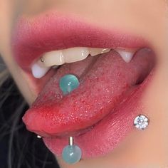 a woman's tongue with some piercings attached to her lip and on top of it