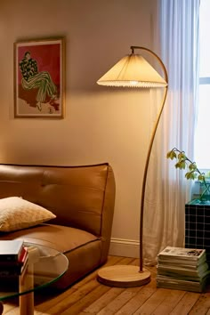 a living room with a couch, lamp and books on the floor