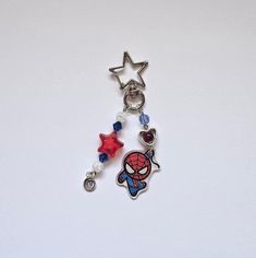 a keychain with a spiderman charm attached to it's side on a white surface