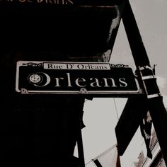 a black and white street sign hanging off the side of a building