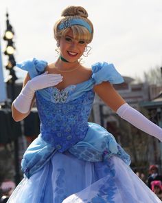 a woman in a blue dress and white gloves