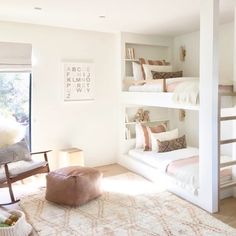 a bedroom with bunk beds and a chair in the corner next to a large window