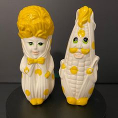 two yellow and white ceramic salt and pepper shakers with faces painted on the sides