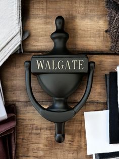 a wall mounted coat hook with the word walgate on it's center piece