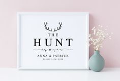 the hunt is upon wedding guest sign in white frame next to a vase with baby's breath flowers