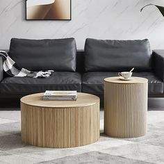 a living room with two black leather couches and a coffee table in the middle